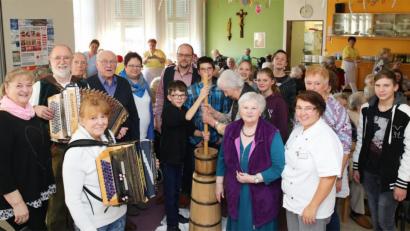 Bild: JOCHEN NEUMANN 
ERBENDORF
Viel Spaß hatten die Senioren und die jungen Praktikanten der Mittelschule beim Ausbuttern im BRK-Seniorenwohn- und Pflegeheim. Auf dem Bild die Musikgruppe Storek (links), Manuela Ruf vom BBZ (hintere Reihe, Fünfte von links), Heimleiter Andreas Wöhrl (hintere Reihe, Sechster von links) und die "Fachfrau" fürs Ausbuttern, Irene Heinl (Zweite von recht).