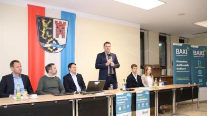 Bild: Thomas Dobler
Landrat Thomas Ebeling (stehend) leitete die Konferenz im Landratsamt, die Bürgermeistern, Verwaltungsbeamten und anderen Zuständigen den letzten Planungsstand beim Anrufbus nahe brachte. Am 16. Dezember geht es mit dem BAXI los.