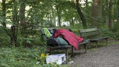 Symbolbild: Paul Zinken
Ein Obdachloser liegt am frühen Morgen auf einer Bank in einem Park.