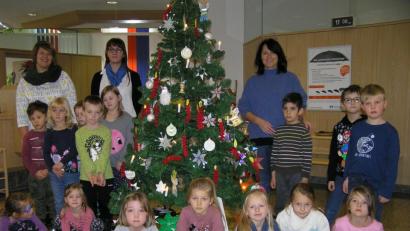 Bild: öt
Kindergartenleiterin Daniela Burger (hinten von rechts), Geschäftsstellenleiterin Cornelia Wöhrl und pädagogische Fachkraft Petra Söllner unterstützten die Vorschulkinder beim Schmücken des Christbaums in der Raiffeisenbank Neusorg.
