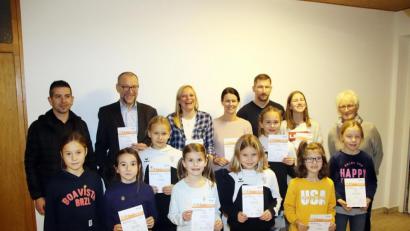 Bild: jma
Schon im Sommer hat die Abnahme des Deutschen Sportabzeichens stattgefunden, nun dürfen die Teilnehmer ihren Lohn dafür entgegennehmen. Stolz präsentieren sie zusammen mit Hannelore Ott (re.) und Zweitem Bürgermeister Karl Lorenz (Zweiter von links) ihre Abzeichen und Urkunden.