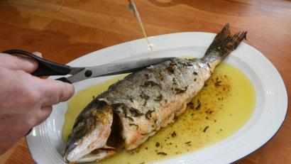 Bild: Gabi Schönberger
Nach dem Braten wird das Küchengarn von der Dorade entfernt.