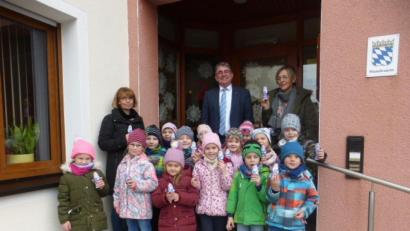 Bild: nbu
Mit leuchtenden Augen schmücken die Kinder der„Maxi-Gruppe den Eingangsbereich des Freihunger Rathauses. 
Mit ihnen freuen sich (hinten, von links): Kindergartenleiterin Christine Götz, Bürgermeister Norbert Bücherl und Erzieherin Christine Setzer.