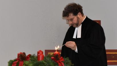 Bild: rgr
Pfarrer André Fischer zündet am Beginn des neuen Kirchenjahres die erste Kerze am Adventkranz an.
