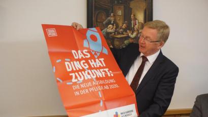 Bild: jut
Andreas Westerfellhaus, der Pflegebevollmächtigte der Bundesregierung, zeigt in Kastl ein Plakat der neuen Pflegekampagne.