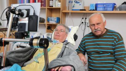 Bild: Wolfgang Steinbacher
Der Sprachcomputer ist ihre Verbindung: Karl Manglberger (rechts) kümmert sich seit neun Jahren um seine an ALS erkrankte Frau Renate, die durch die Krankheit nicht mehr sprechen kann.
