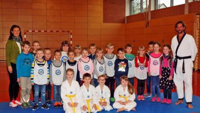 Bild: sön
Rektorin Christine Kölbl (links) mit der Klasse 2a nach der Taekwondo-Schnupperstunde mit Trainer Manfred Dotzler-Brenner (rechts) und seinem Team Hanna, Andreas, Florian und Lilit (vorne von links).