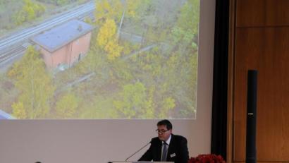 Bild: Ingmar Höfgen
Auktionator René Silva (am Pult) gab für das Vilsecker Stellwerk (im Hintergrund als Luftbildaufnahme) dem einzigen Angebot in Höhe von 5000 Euro den Zuschlag.