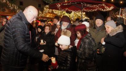 Bild: Hirsch
Dekan Hans Amann (links) reichte das Friedenslicht weiter an die Besucher des Weihnachtsmarktes.