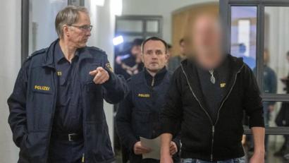 Bild: Armin Weigel/dpa
Der Angeklagte (rechts) geht neben zwei Polizisten in den Verhandlungssaal des Landgerichts.
