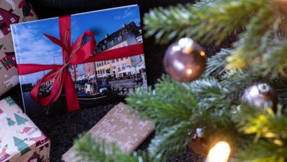 Bild: Swen Pförtner/dpa
Geschenke liegen unter einem mit Kerzen und Kugeln geschmücktem Weihnachtsbaum.