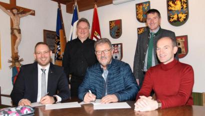 Bild: pi
Bürgermeister Johann Maurer (sitzend, Mitte) unterzeichnet im Beisein von Geschäftsleiter Günter Gschwindler (sitzend, rechts) den Vertrag für das dritte Verfahren im Breitbandausbau. Darüber freuen sich auch Enrico Delfino (sitzend, links) und Josef Markl (hinten, rechts) von der Telekom sowie Diplom-Ingenieur Günther Pichlmaier.