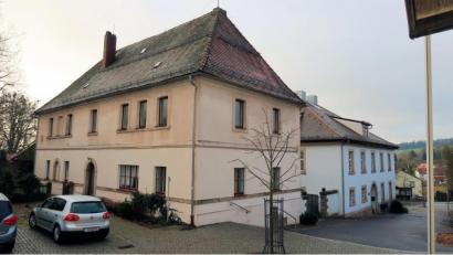 Bild: bsc
Die Gemeinde Friedenfels will das leerstehende ehemalige Lehrerwohnhaus (Bild) neben der Grundschule (rechts) zum Rathaus umbauen. Die Verwaltung soll von der Gemmingenstraße auf den Kolpingplatz umziehen.