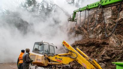 Bild: Clemens Hösamer
Per Fernsteuerung wird das Bohrgerät am Hang bedient. Normalerweise ist es an einem Schreitbagger (untenh) montiert. Für Löcher in großen Höhen wie hier am Wenzel kommt die Lafette zum Einsatz.