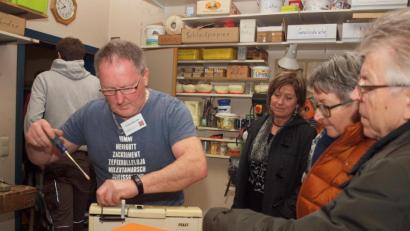 Bild: sön 
Ehrenamtliche Tüftler mit Sinn für Humor: “Himmi Herrgott Zackriment” kann man auf dem T-Shirt von Franz Bleicher lesen, der gerade eine Nähmaschine repariert.