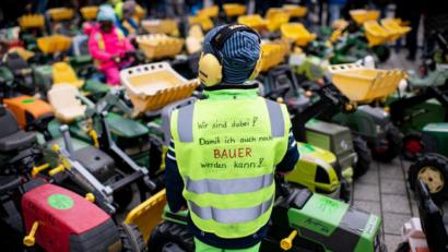 Bild: Bernd von Jutrczenka/dpa
Ein kleiner Junge steht bei einer Protestaktion von Bauern gegen das Agrarpaket der Bundesregierung vor Kinder-Treckern.