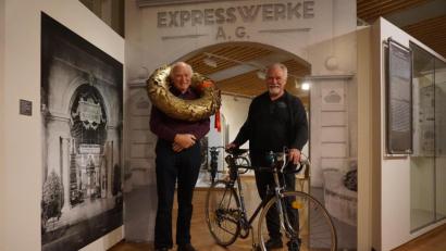 Bild: jut
Klaus Stolz (links), der letzte Express-Lehrling in Neumarkt, und Peter Klesel, Vorstand der Express-IG, posieren im Stadtmuseum Neumarkt mit dem Siegerkranz von Rennfahrer Karl Kittsteiner sowie einem Rennrad, dem "Berufsfahrermodell".