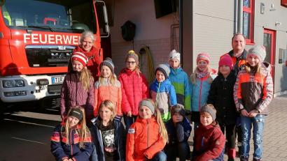 Bild: bsc
Schule einmal anders: Lehrerin Claudia Wölke (hinten links) war mit ihrer Klasse zu Gast bei der Feuerwehr. Zum Unterricht steuerten Feuerwehrmitglieder wichtige Informationen bei. Zweiter Kommandant Jürgen Schultes (hinten rechts) brachte die Kinder abschließend mit dem Feuerwehrauto zurück zur Schule.