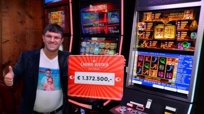 Bild: Casinos Austria/dpa
Gewinner Leon Tsoukernik steht mit einem symbolischen Scheck über die Gewinnsumme von 1,37 Millionen Euro neben Spielautomaten im Casino Seefeld.