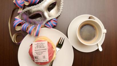 Bild: Tobias Hase
Ein Krapfen mit einem Kassenbon aus Fondant, einer essbaren Zuckermasse und eine Tasse Kaffee. Foto: Tobias Hase/dpa