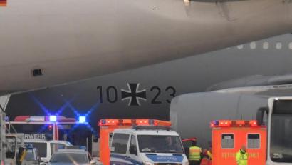 Bild: Boris Roessler
Rettungskräfte und Polizisten stehen neben dem Flugzeug bereit. Foto: Boris Roessler/dpa