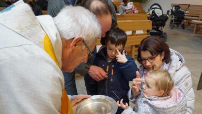 Bild: wec
Pfarrer Josef Beer mit einer Familie, die sich gegenseitig mit Weihwasser bekreuzigte.