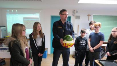 Bild: jzk
Wie Fahrradhelm Leben retten kann, demonstrierte Polizeihauptmeister Carsten Landgraf den Sechstklässlern beim Melonentest.