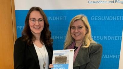 Bild: Bild: exb/StMGP
Gesundheitsministerin Melanie Huml (rechts) holt für Paula Herrmann eine mit 600 Euro monatlich dosierte Finanzspritze in Form eines Landarzt-Stipendiums aus dem Retro-Doktorenkoffer.