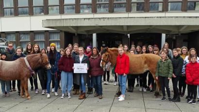 Bild: Dobmeier
Zur Abholung der 750 Euro-Spende kommt das Team des Reittherapiezentrums Oberpfalz mit zwei Pferden bei den Schülerinnen an die Sophie-Scholl-Realschule vorbei.