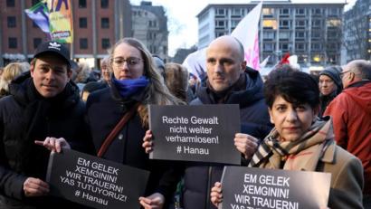 Bild: Oliver Berg/dpa
Mit Plakaten nehmen Bürger an einer Kundgebung teil. Das Aktionsbündnis will seine Solidarität mit den Angehörigen der Ermordeten und den Überlebenden des rassistischen Anschlags von Hanau ausdrücken.