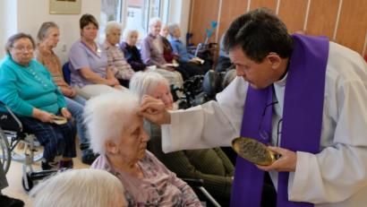 Bild: le
Pfarrer Max Früchtl zeichnet das Aschenkreuz auf die Stirn der Messebesucher.