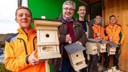 Bild: Martin Hertel/exb
Sozialer Wohnungsbau für Singvögel: Jonas Plessgott (links), Ulli Stöhr und Korbinian Scherm (rechts) präsentieren die Vogelnistkästen, die sie für ein Forschungsprojekt der Universität Bayreuth an Robert Pfeifer und Lucas Fäth übergeben.