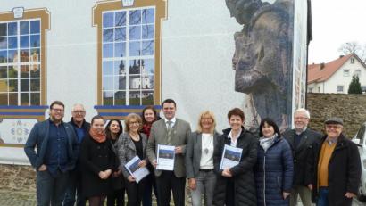 Bild: Portner
Die Fassade des Centrum Bavaria Bohemia weist auf das Projekt „Barockes Kulturerbe erleben“ hin. Die Jahresbilanz 2019 lässt die Verantwortlichen um CeBB-Leiterin Veronika Hofinger (ab Vierte von rechts), Trägervereinsvorsitzende Irene Träxler, Kuratoriumsvorsitzender Landrat Thomas Ebeling und die CeBB-Mitarbeiter Ivana Danisch, Susanne Setzer, Veronika Kaštánková (EU-Freiwilligendienst), Veronika Krístková, Erich Schlicker und David Vereš strahlen. Auch die beiden Vorsitzenden der Kulturstiftung Bavaria Bohemia, Hans Eibauer (von rechts) und Rudolf Ebenth, sowie Bürgermeisterin Birgit Höcherl freuen sich über die gute Entwicklung.