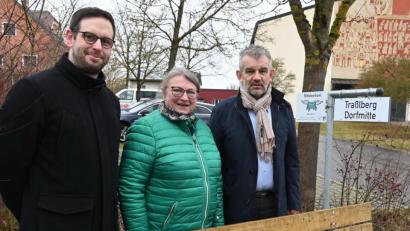 Bild: gf
Pfarrer Dominik Mitterer, Waltraud Lobenhofer und Bürgermeister Roger Hoffmann stellen das neue Mitfahrerbanklerl bei der katholischen Kirche St. Michael vor . Mit der Tafel „Traßlberg Dorfmitte“ wird angezeigt, dass man gerne nach Traßlberg mitfahren würde.
