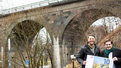 Bild: Stadt Marktredwitz/exb
Die Drei-Bogen-Brücke ist auf der fünften Serie des MAK-Gutscheins abgedruckt – sehr zur Freude von Sebastian Macht und Innenstadtkoordinator Dominik Hartmann (von rechts).