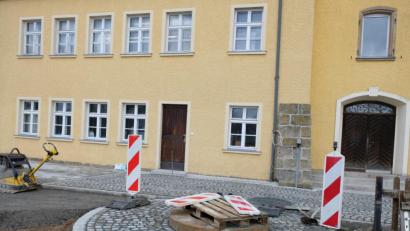 Bild: do
Ein Brunnenkopf aus Sandstein weist auf einen kleinen baulichen Schatz im alten Tremmersdorfer Schulgarten hin: den etwa 250 Jahre alten Brunnen. Dessen Erhaltung ist wie die Pflasterung des Schulahusvorplatzes Teil der Neugestaltung des gesamten Schulgartens.