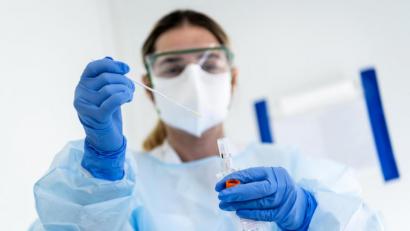 Bild: Jean-Christophe Bott/KEYSTONE/dpa
Eine Krankenschwester steckt eine Probe mit einem Nasenabstrich eines Patienten, der auf das neuartige Coronavirus getestet wird, in einen Behälter.