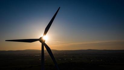 Bild: Swen Pförtner/dpa
Die Sonne geht hinter einer Windkraftanlage unter.