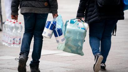 Bild: Kay Nietfeld/dpa
Passanten tragen Toilettenpapier, Wasser und weitere Einkäufe.