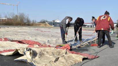 Bild: hcz
Die Zirkusmitarbeiter werden mit dem Reinigen der Zelt-Plane beschäftigt, weil sonst keine Arbeit da ist.
