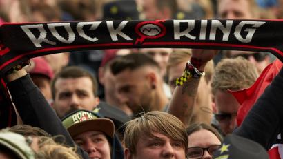 Archivbild: Thomas Frey/dpa
Ein Festivalbesucher hält einen Schal mit der Aufschrift „Rock am Ring“ im Publikum.