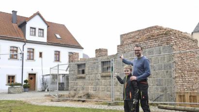 Bild: Petra Hartl
Michael Lang deutet mit Sohn Korbinian auf die Mauerreste des ehemaligen Kuhstalls, auf denen er einen neuen Stadl für ein zusätzliches gastronomisches Angebot neben der Zoigstube "Brucksaler" baut.