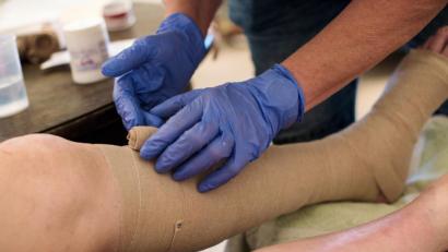 Bild: Jana Bauch/dpa
Eine ambulante Pflegerin bandagiert die Beine eines alten Mannes (Symbolbild). Der Landkreis Amberg-Sulzbach und die Stadt Amberg suchen wegen der Corona-Epidemie freiwillige Helfer für den Einsatz im Gesundheitswesen.