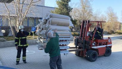 Bild: Michael Kraus/exb
Die Stützpunktfeuerwehr Oberviechtach hilft mit ihrem Stapler bei der Anlieferung der Bettgestelle samt Matratzen für das Hilfskrankenhaus.