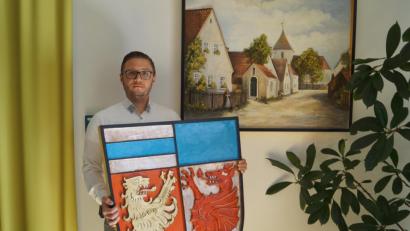 Bild: du
In dankbarer Erinnerung an den verstorbenen Holzbildhauer Wendelin Sperl, der auch in Schirmitz elf Jahre lang wirkte, zeigt Bürgermeister Ernst Lenk mit dem farbigen Gemeindewappen und dem Holzrelief von Alt-Schirmitz zwei Meisterwerke des Künstlers.