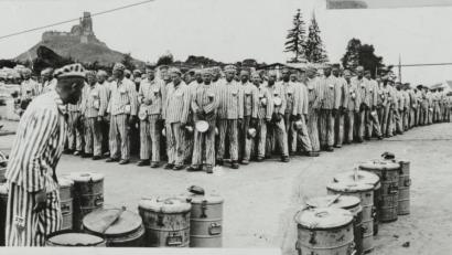 Bild: SS/NIOD Institut für Kriegs-, Holocaust- und Genozidforschung, Amsterdam
KZ-Häftlinge warten in Flossenbürg auf die Ausgabe von Essen.