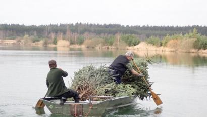 Bild: M. Merkel/exb
Mit vereinter Muskelkraft werden die ehemaligen Christbäume auf den Dießfurter See hinaus gerudert