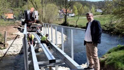 Bild: bö
Die Stahlkonstruktion für den Lauterachsteg als weiteren Zugang zum Hammerschloss ist gesetzt. Ab Mitte Mai wird die Fußgängerbrücke nutzbar sein, sagte Bürgermeister Peter Braun (rechts) an der Baustelle.