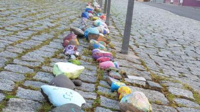 Bild: mng
Bemalte Steine als Zeichen gegen Einsamkeit. Derzeit legen sie Kinder und auch Erwachsene am Kirchplatz vor der Stadtpfarrkirche Sankt Georg ab. Wichtig ist, dass die bunten Steine dort liegen bleiben und so die Schlange immer länger wird, ganz nach dem Motto „Lasst uns einfach etwas Freude schenken“.