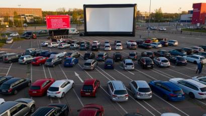 Archivbild: Jan Woitas/dpa
Besucher stehen mit ihren Autos im Autokino.